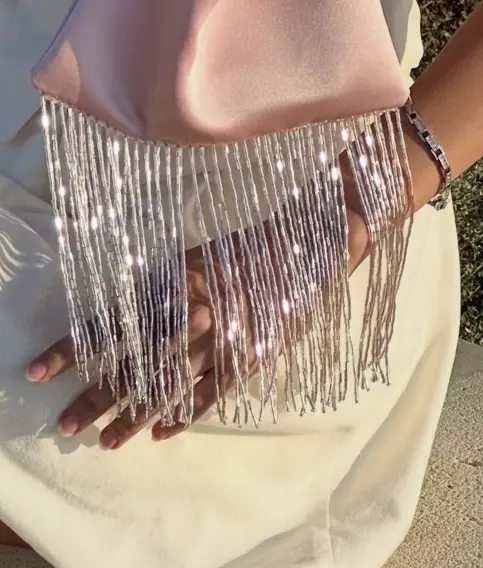 Close-up of rose satin and the silver-lit beads of the fringe