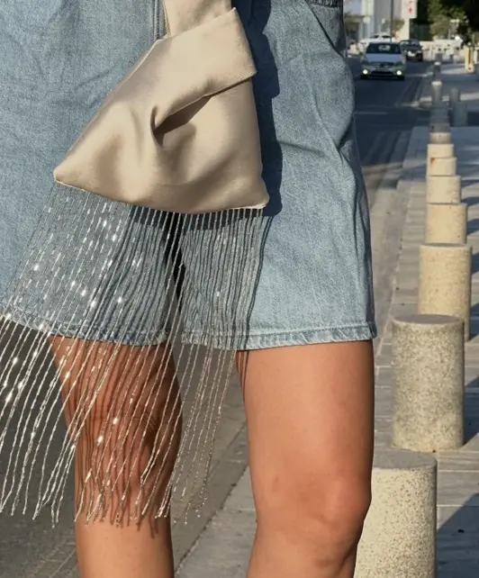 Close-up of champagne satin and its pale glass-bead fringe