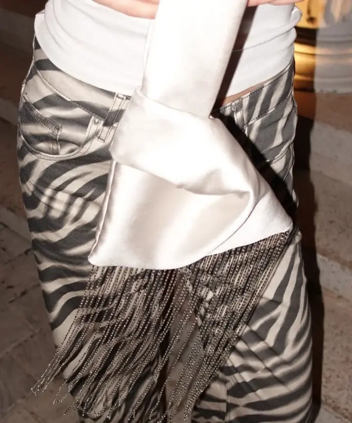 Close-up of champagne satin and its pale glass-bead fringe