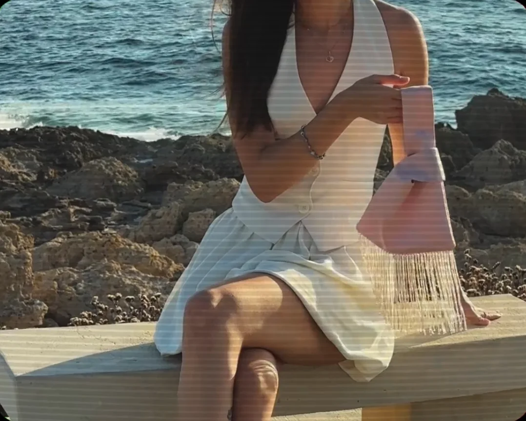 Blush satin bag held by the sea